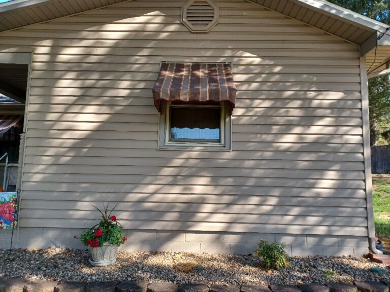 Small striped awning fitted over a house window in southeastern Ohio