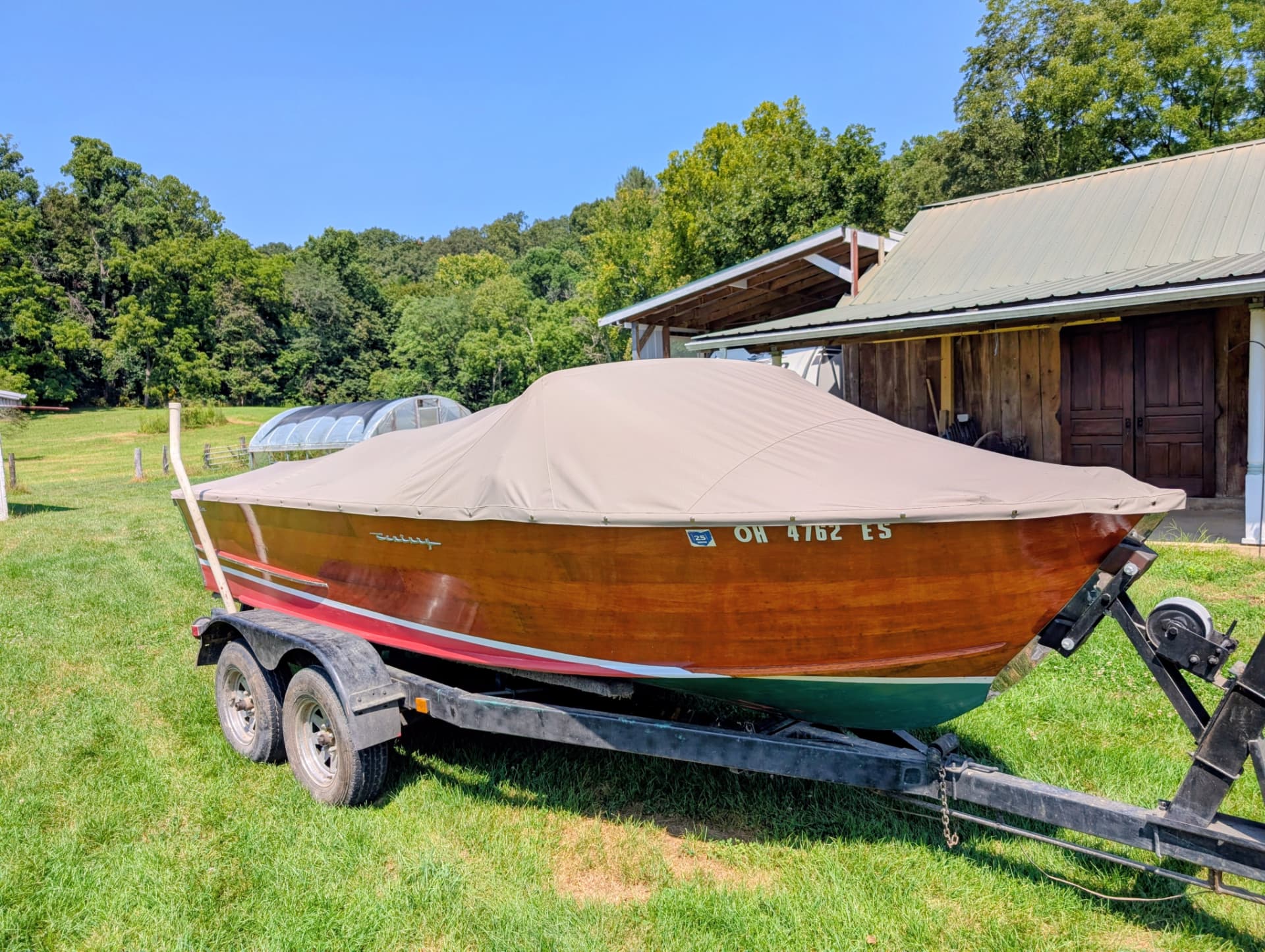 Wooden boat protected by a fitted tan cover in southeastern Ohio
